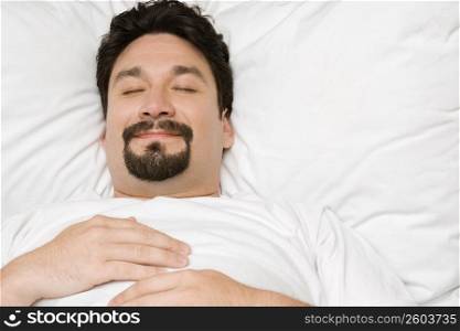 Close-up of a mid adult man sleeping on the bed