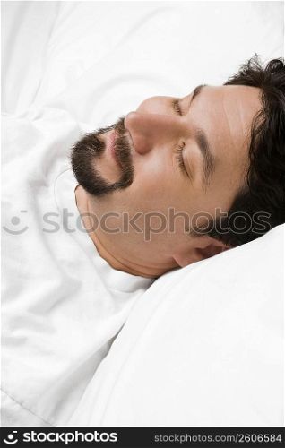 Close-up of a mid adult man sleeping on the bed