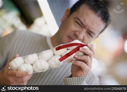 Close-up of a mid adult man smelling garlic