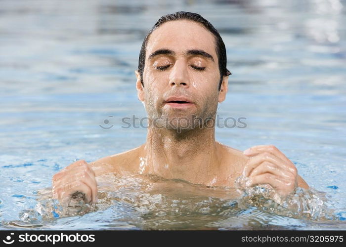 Close-up of a mid adult man swimming in a swimming pool