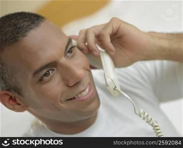 Close-up of a mid adult man talking on the telephone and smiling