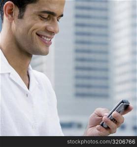 Close-up of a mid adult man text messaging and smiling