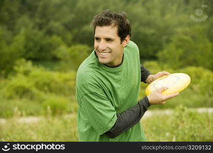 Close-up of a mid adult man throwing a plastic disc