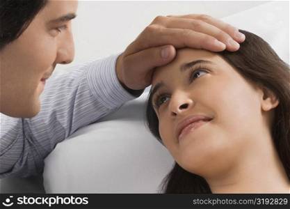 Close-up of a mid adult man touching a young woman&acute;s head