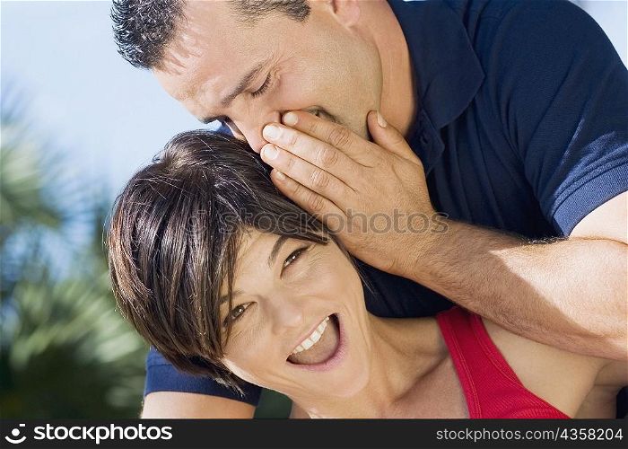 Close-up of a mid adult man whispering into a mid adult woman&acute;s ear