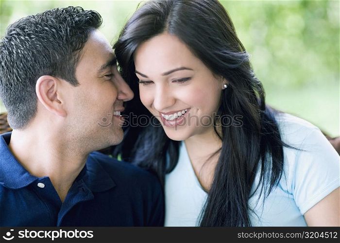 Close-up of a mid adult man whispering into a young woman&acute;s ear