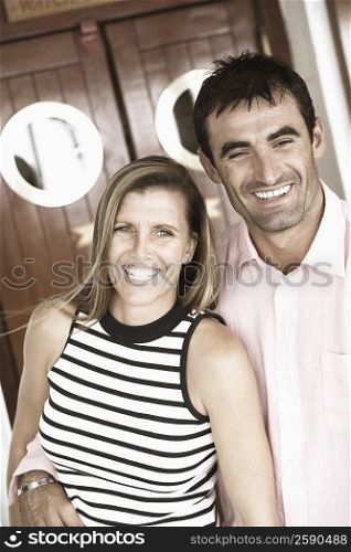 Close-up of a mid adult man with his arm around a mid adult woman and smiling