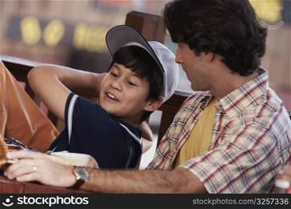 Close-up of a mid adult man with his son pretending to play baseball