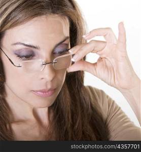 Close-up of a mid adult woman adjusting her eyeglasses