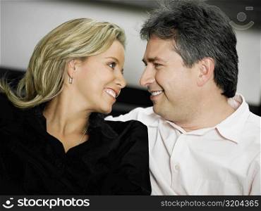Close-up of a mid adult woman and a mature man looking at each other and smiling