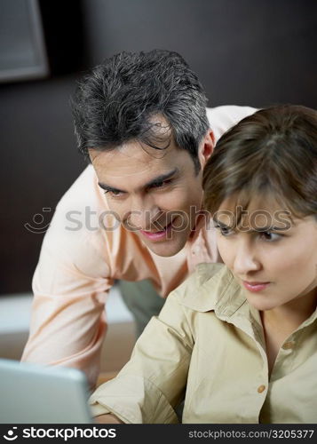 Close-up of a mid adult woman and a mature man using a laptop