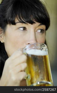 Close-up of a mid adult woman drinking a glass of beer