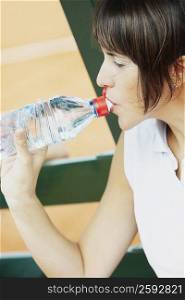 Close-up of a mid adult woman drinking water from a bottle