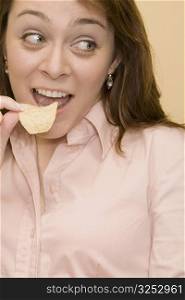 Close-up of a mid adult woman eating a potato chip
