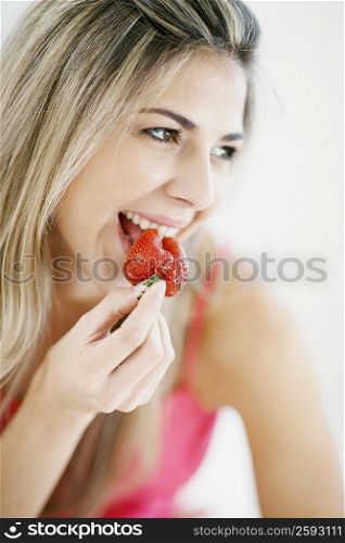 Close-up of a mid adult woman eating a strawberry