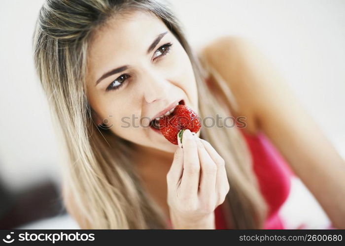 Close-up of a mid adult woman eating a strawberry