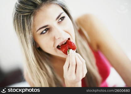 Close-up of a mid adult woman eating a strawberry