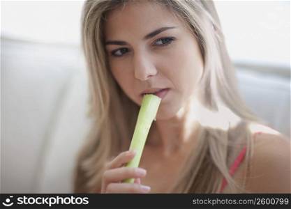 Close-up of a mid adult woman eating celery