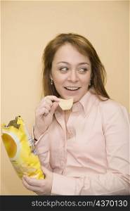Close-up of a mid adult woman eating potato chips