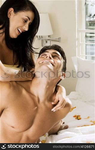 Close-up of a mid adult woman embracing a mid adult man on the bed