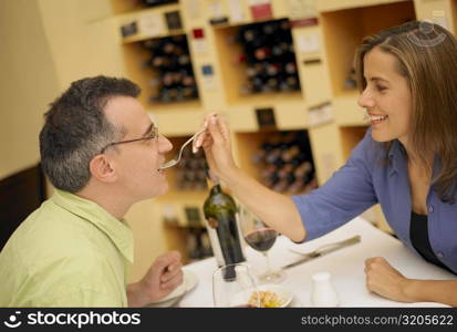 Close-up of a mid adult woman feeding a mid adult man