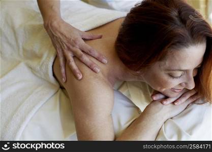 Close-up of a mid adult woman getting a shoulder massage from a massage therapist