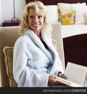 Close-up of a mid adult woman holding a book and smiling
