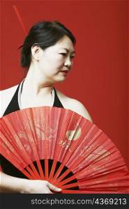 Close-up of a mid adult woman holding a folding fan