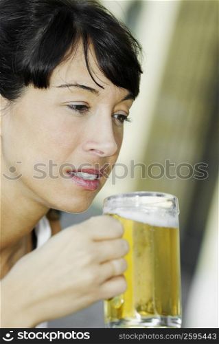 Close-up of a mid adult woman holding a glass of beer