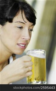 Close-up of a mid adult woman holding a glass of beer