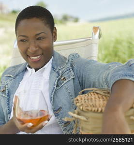 Close-up of a mid adult woman holding a glass of wine and smiling