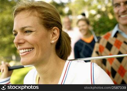 Close-up of a mid adult woman holding a golf club and smiling