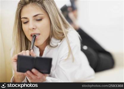 Close-up of a mid adult woman holding a pen and a calculator