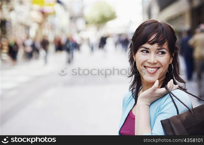 Close-up of a mid adult woman holding a shopping bag