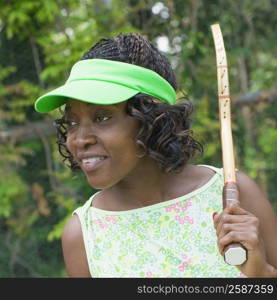 Close-up of a mid adult woman holding a tennis racket and smiling