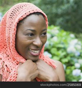 Close-up of a mid adult woman holding her scarf and smiling