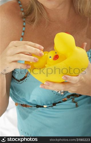Close-up of a mid adult woman holding rubber ducks