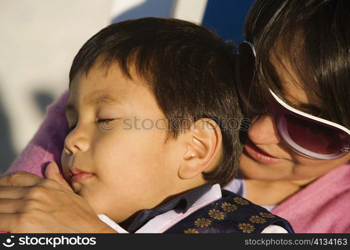 Close-up of a mid adult woman hugging her son