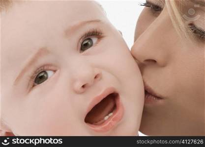 Close-up of a mid adult woman kissing her son