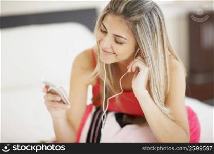 Close-up of a mid adult woman listening to an MP3 player