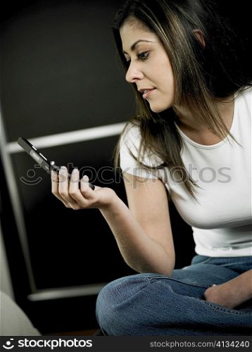 Close-up of a mid adult woman looking at a mobile phone