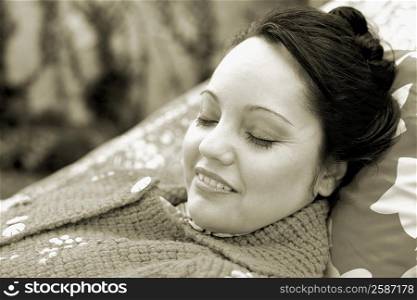 Close-up of a mid adult woman lying down on a hammock and smiling