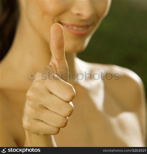 Close-up of a mid adult woman making a thumbs up sign