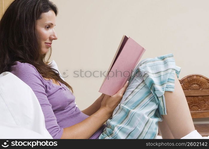 Close-up of a mid adult woman reading a book and smirking