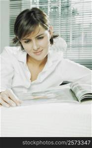 Close-up of a mid adult woman reading a magazine