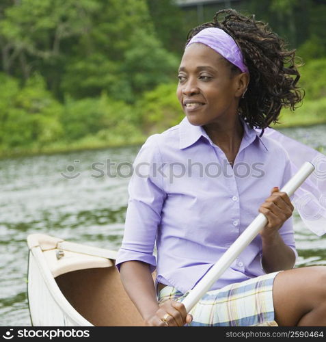 Close-up of a mid adult woman sitting on a boat and smiling