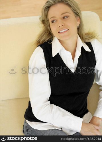 Close-up of a mid adult woman sitting on a couch and smiling