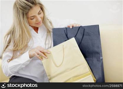 Close-up of a mid adult woman sitting with shopping bags