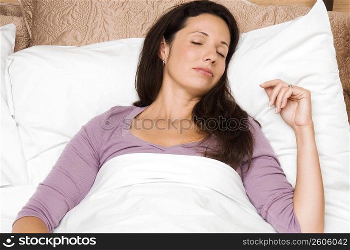 Close-up of a mid adult woman sleeping on the bed