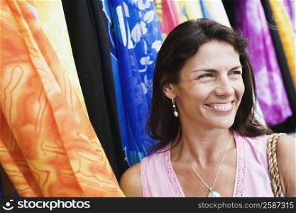 Close-up of a mid adult woman smiling at a clothing store